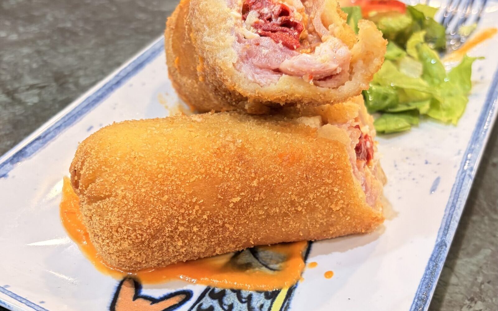 Flamenquín casero cortado, con ensalada